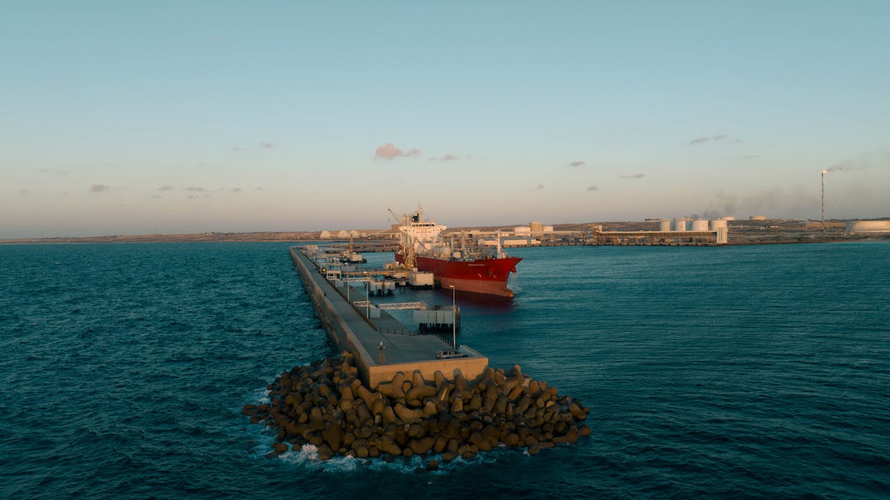 Aerial view of a large cargo ship at an industrial harbor in Libya during daytime.